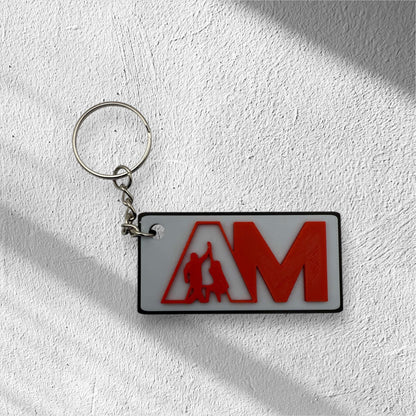 Modern custom logo keychain for businesses featuring red AM letters on white plate