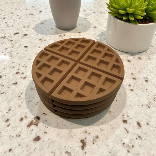 Stack of round brown waffle coasters on a kitchen countertop
